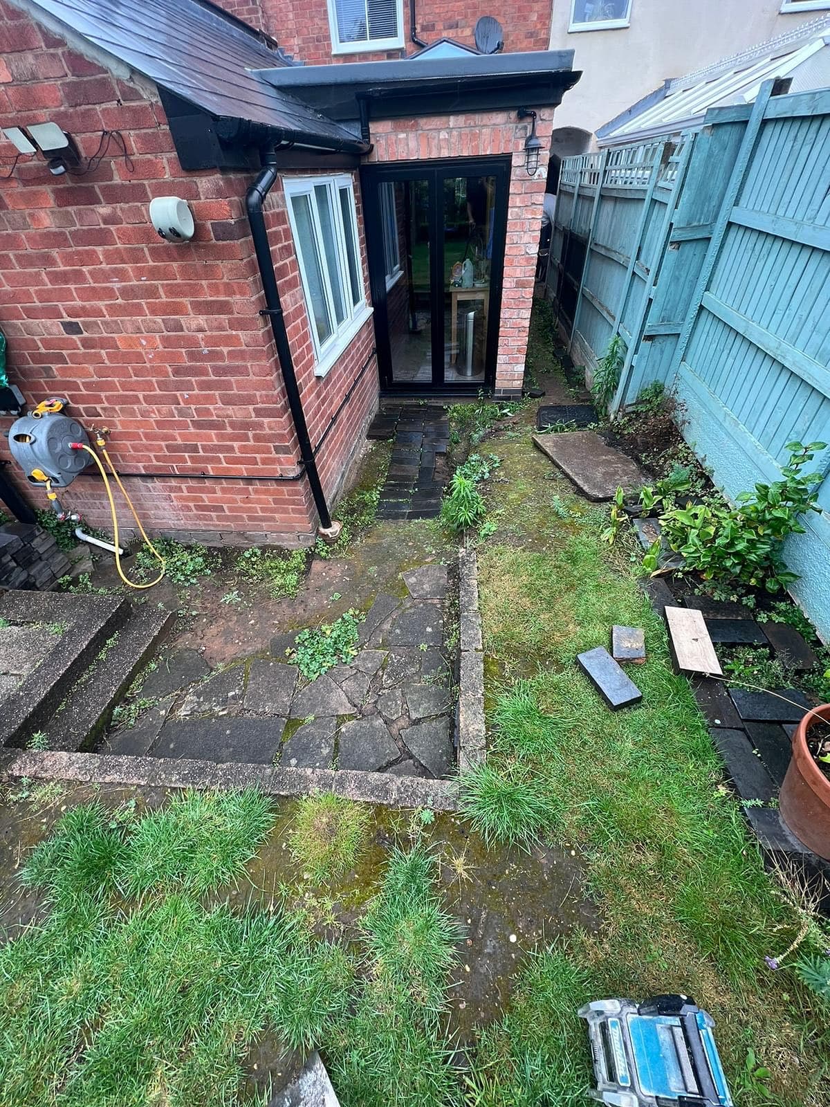 Before - Overgrown and tired patio area